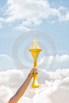 Composite image of sporty woman posing and smiling with olympic torch