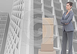 Composite image of stack of carboard boxes and caucasian businesswoman against tall buildings