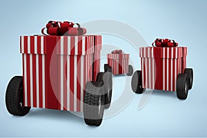 Composite image of striped red and white gift box on wheels