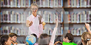 Composite image of students raising hands while teacher teaching