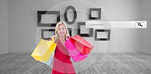 Composite image of stylish blonde in red dress holding shopping bags