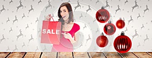 Composite image of stylish brunette in red dress showing sale bag