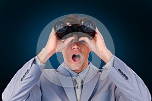 Composite image of suprised businessman looking through binoculars