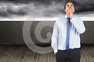 Composite image of thinking businessman touching his chin