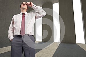 Composite image of thinking businessman touching his glasses