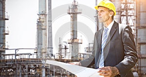 Composite image of thoughtful architect holding blueprint