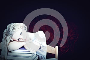 Composite image of tired teeenager sleeping in a library