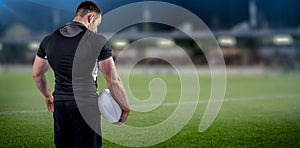 Composite image of tough rugby player holding ball