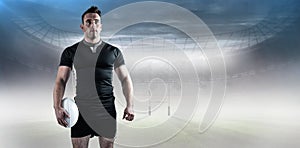 Composite image of tough rugby player holding ball