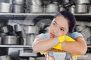 Composite image of troubled woman leaning on a mop