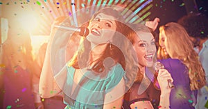 Composite image of two beautiful women singing song together