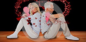 Composite image of unhappy couple sitting while holding broken heart