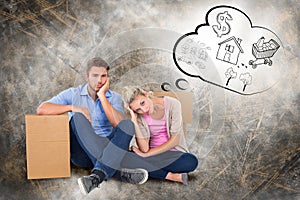 Composite image of unhappy young couple sitting beside moving boxes