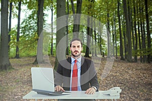 Composite image of unsmiling businessman sitting at desk photo
