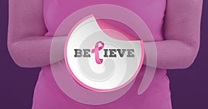 Composite image of woman with breast cancer awareness ribbon and believe text