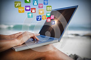 Composite image of woman sitting on beach using her laptop 3d