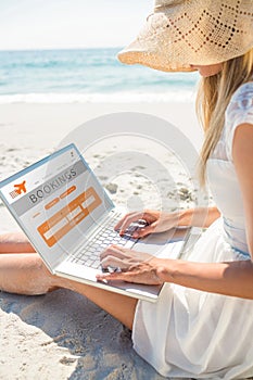 Composite image of woman using laptop and wearing hat