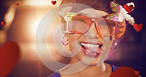 Composite image of woman wearing fancy sunglasses making funny faces in bar