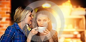 Composite image of woman whispering into other woman ear while having a cup of coffee