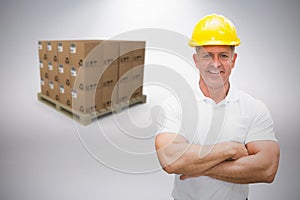 Composite image of worker wearing hard hat in warehouse
