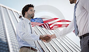 Composite image of young businessmen shaking hands in office