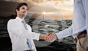 Composite image of young businessmen shaking hands in office