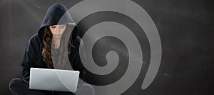 Composite image of young female hacker using laptop while sitting