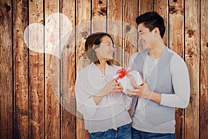 Composite image of young man giving present to woman