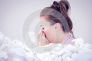 Composite image of young woman blowing her nose