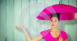 Composite image of young woman carrying pink umbrella