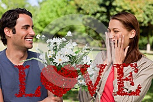 Composite image of young woman holding her hands against her face when presented with flowers