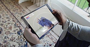 Composite of man sitting at home, watching judo match on tablet