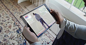 Composite of man sitting at home watching judo match on tablet