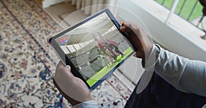 Composite of man sitting at home, watching rugby match on tablet