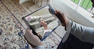 Composite of man sitting at home watching rugby match on tablet