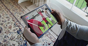 Composite of man sitting at home watching rugby match on tablet