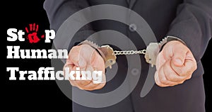 Composite of stop human trafficking text and midsection of caucasian businessman with handcuffs