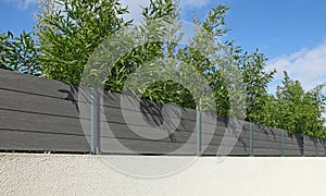 Composite wood palisade on a garden fence wall