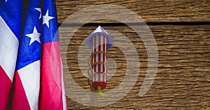 Composition of american flag and fireworks over wooden table