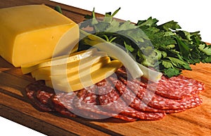 Composition of appetizing sausage, cheese, greens and onions on a wooden board, isolate