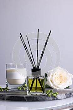 Composition with aromatic reed air freshener on glass table