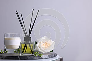 Composition with aromatic reed air freshener on glass table, space for text