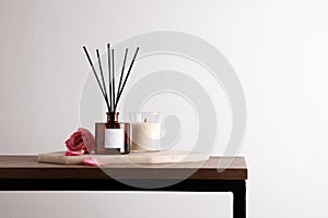 Composition with aromatic reed air freshener on table, space for text