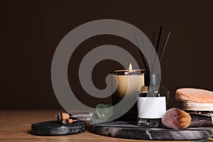 Composition with aromatic reed air freshener on wooden table, space for text
