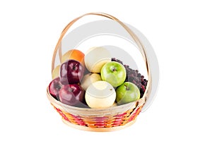 Composition assorted fresh fruits such as orange, Chinese pear, mulberry, red apple and green applein  bamboo wicker basket on whi