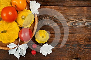 Composition autumn decor frame with pumpkin and red, orange tomatoes on wooden place on dark brown wooden backgound flat