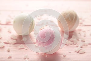 Composition with bath bombs and sea salt on wooden pink background