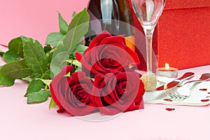 A composition of a beautiful bouquet of roses, glasses and a bottle of champagne creates a romantic card or poster. The concept of