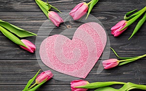 Composition with beautiful tulips and paper heart on wooden background