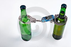 Composition of beer bottles with handcuffs and car.